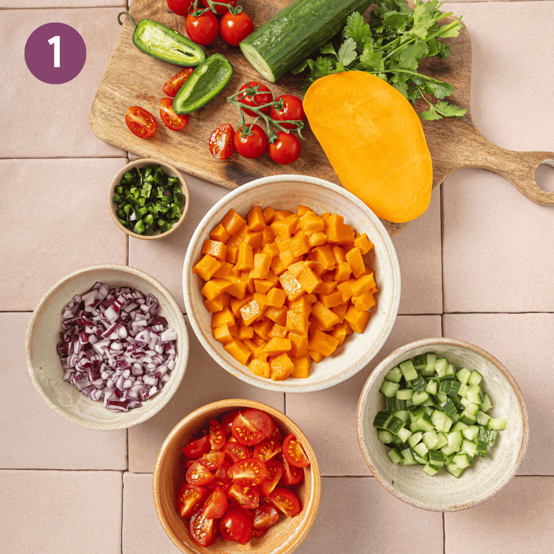 mango salsa ingredients on a wooden cutting board and in various small bowls.