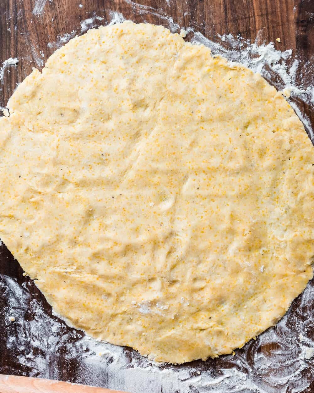 Flattened galette dough on floured work surface.