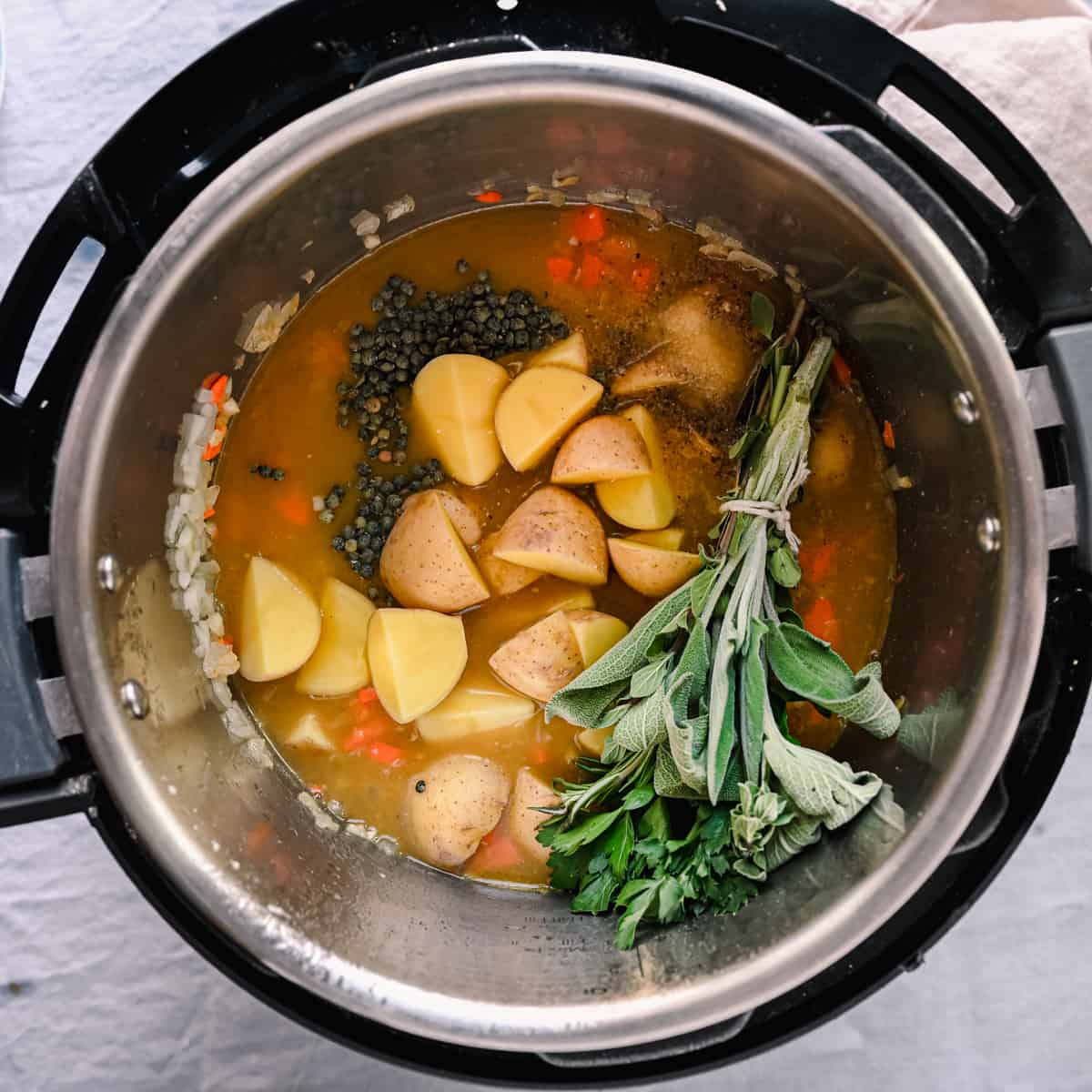 bouqet garni, potatoes, and lentils in vegetable broth in instant pot for soup