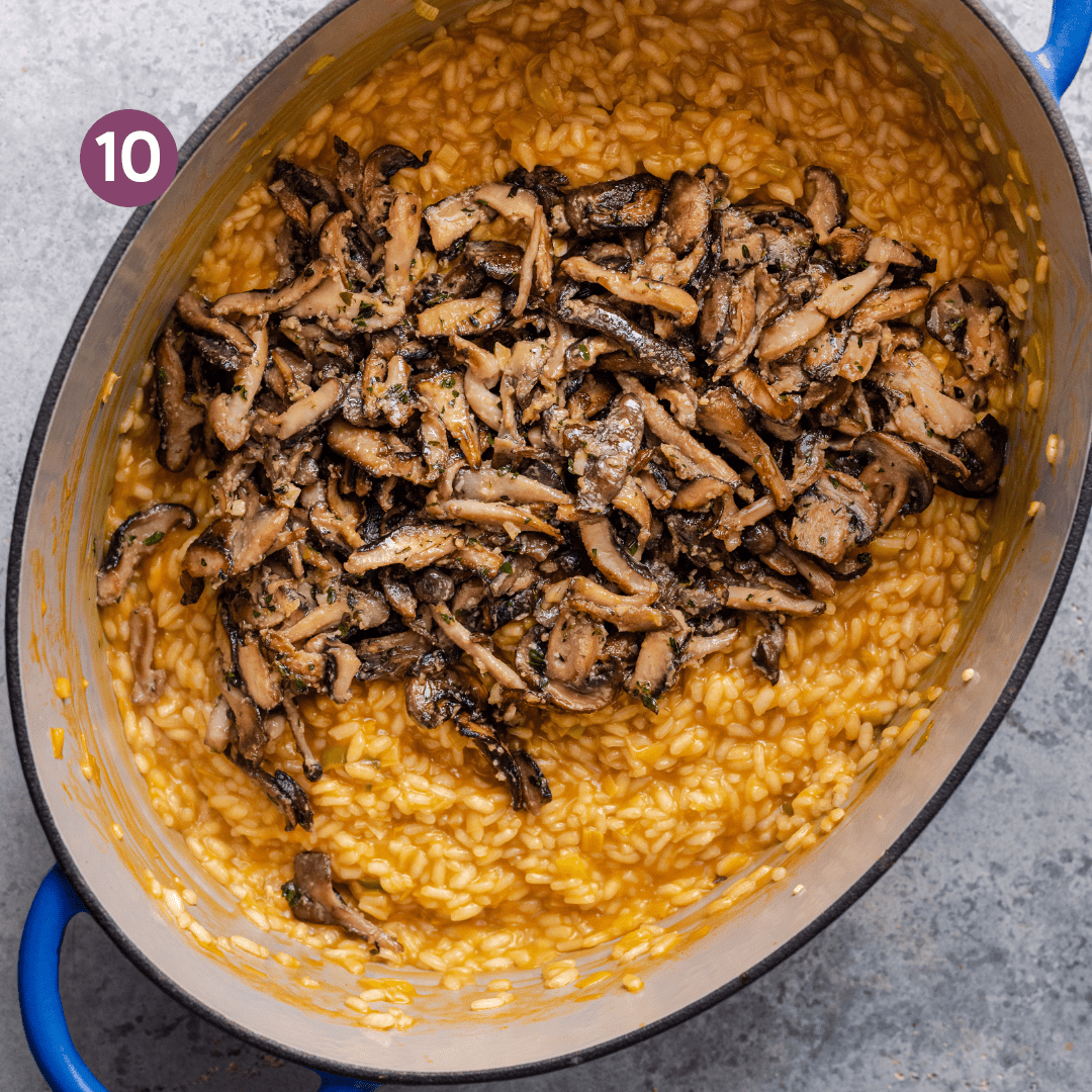 sauteed mushrooms sitting on top of a creamy golden vegan risotto in a dutch oven.