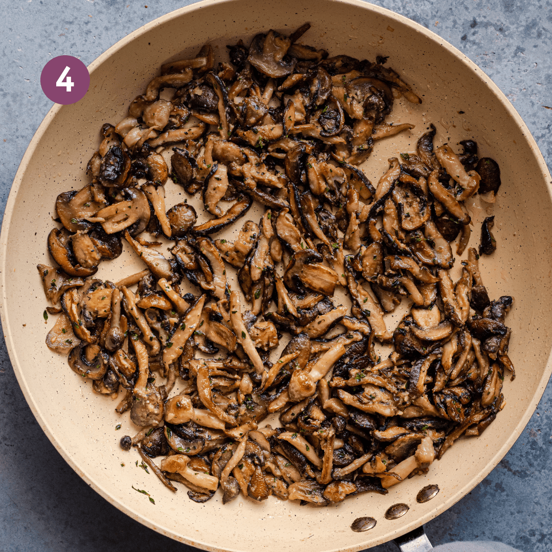 golden brown sauteed mushrooms with herbs and garlic in a saute pan.