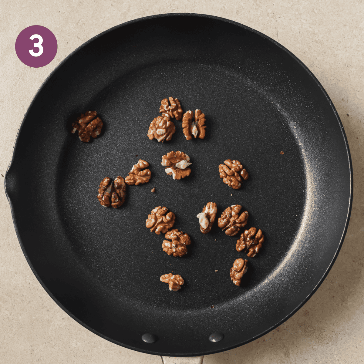 walnuts toasting in a frying pan.
