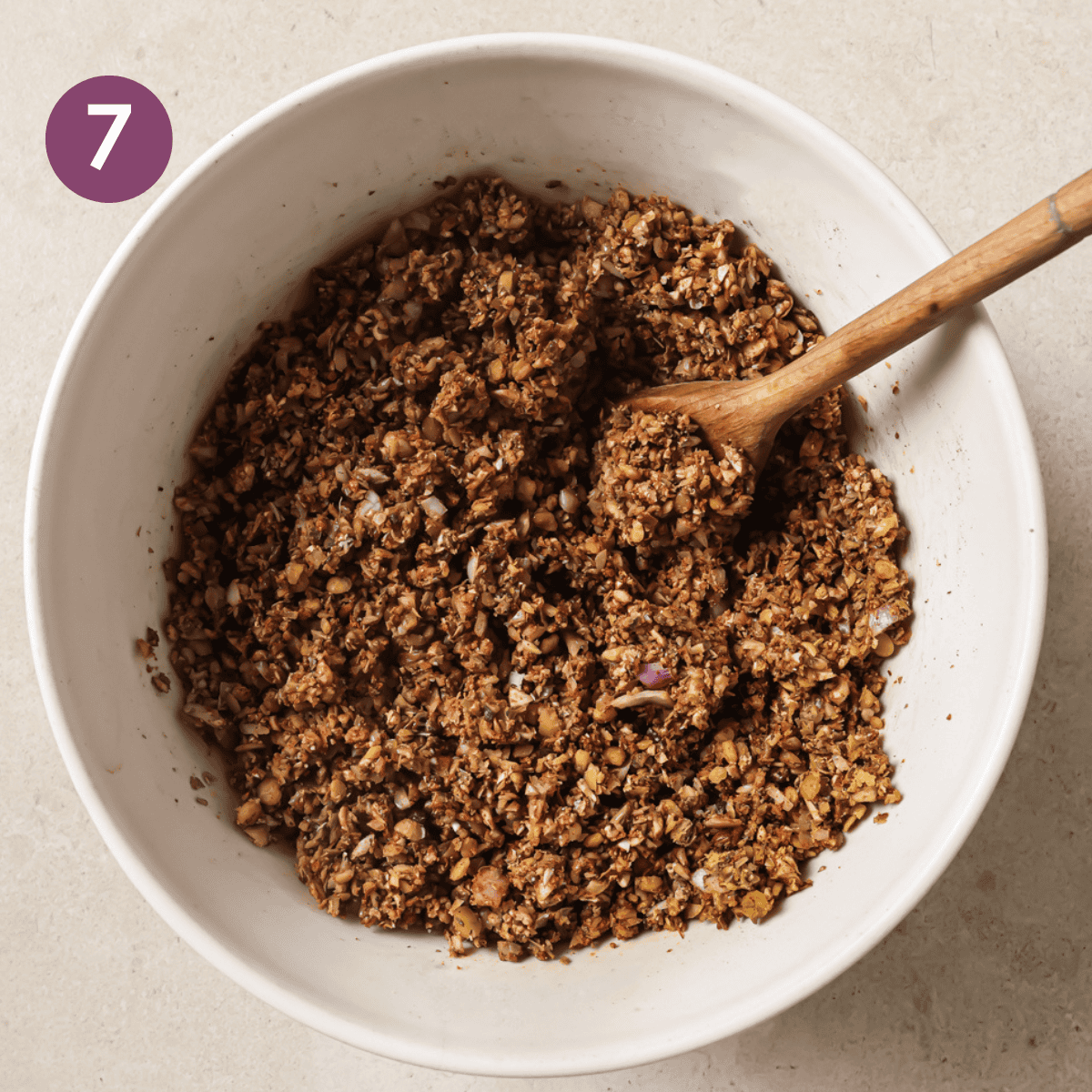 vegan taco meat in a white bowl with a wooden spoon.