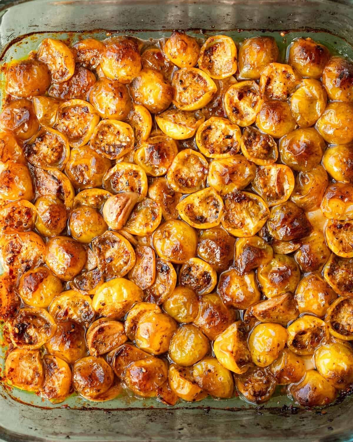 confited golden tomatoes in a baking pan.